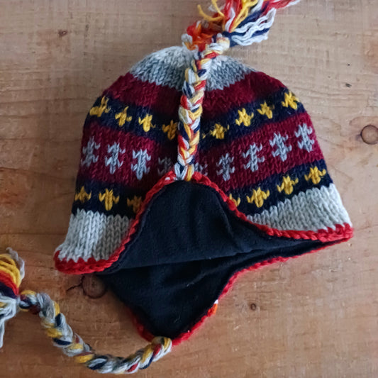 Stay cozy and stylish with our handmade chunky wool earflap hats, crafted in Nepal by skilled women artisans in Kathmandu. Each hat is 100% pure wool and features a soft polar fleece lining for extra warmth and comfort. Perfect for cold winter days, outdoor adventures, or adding a touch of handmade charm to your look.