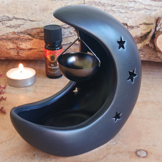 Bring a touch of midnight magic to your home with this black crescent moon oil burner, a beautifully designed piece that blends home fragrance with celestial décor. Featuring delicate star cut-outs, this oil burner casts a soft, glowing light while gently filling your space with the scent of your favourite fragrance or essential oils.