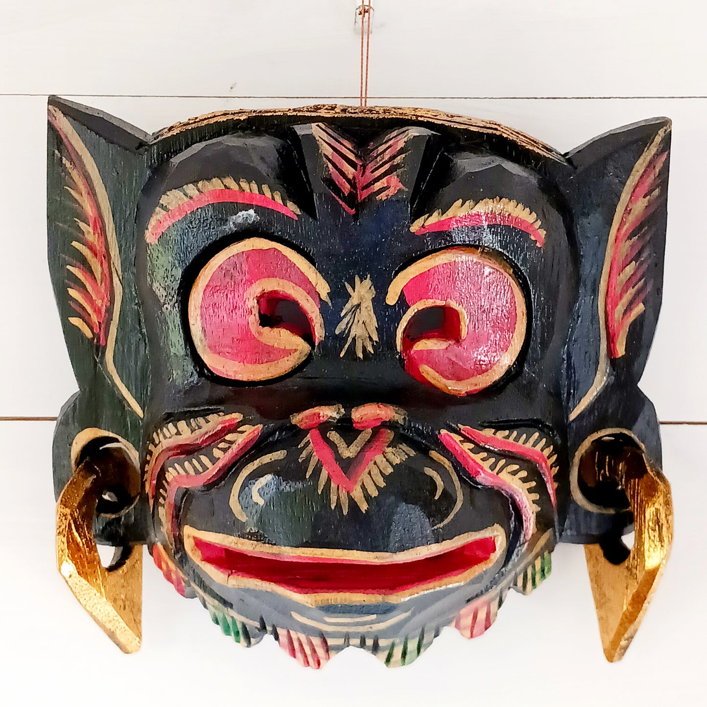 This hand carved and hand painted mask depicts Hanuman, the monkey god. He is integral to the Hindu tale of Ramayana, aiding Rama in the heroic rescue of his wife Sita.