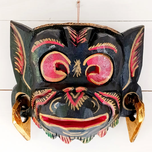This hand carved and hand painted mask depicts Hanuman, the monkey god. He is integral to the Hindu tale of Ramayana, aiding Rama in the heroic rescue of his wife Sita.