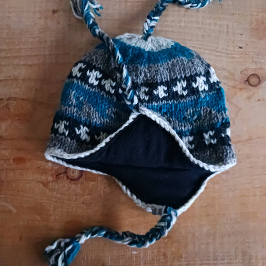 Stay cozy and stylish with our handmade chunky wool earflap hats, crafted in Nepal by skilled women artisans in Kathmandu. Each hat is 100% pure wool and features a soft polar fleece lining for extra warmth and comfort. Perfect for cold winter days, outdoor adventures, or adding a touch of handmade charm to your look.