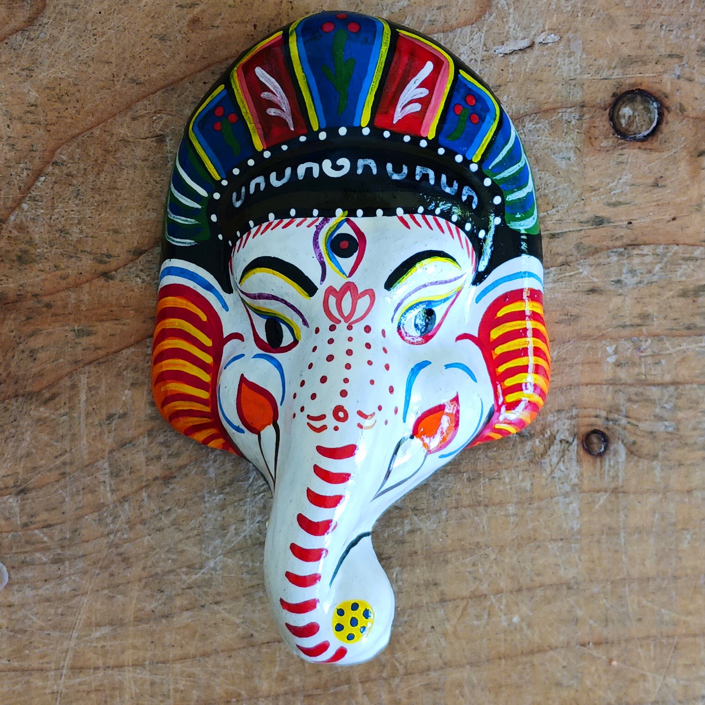 Bring the blessings of Ganesh into your home with this handcrafted terracotta mask from Nepal. Known as the remover of obstacles and the deity of wisdom, learning, and new beginnings, Ganesh is one of the most beloved figures in Hindu tradition. His elephant head and gentle features are beautifully captured in this spiritual wall hanging.