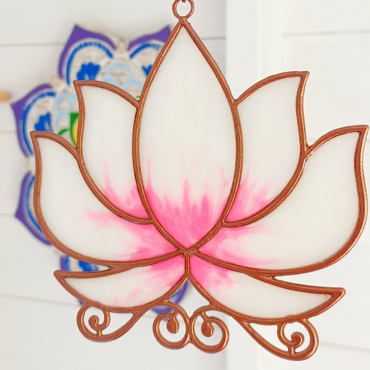 Bring a touch of tranquility to your space with this beautifully crafted lotus flower window hanger. Made from vibrant coloured glass and outlined in sleek metal framing, this piece combines simplicity and elegance. When sunlight passes through, it creates a radiant, uplifting display of color. Hang it in any window to inspire peace, mindfulness, and beauty in your home or workspace.