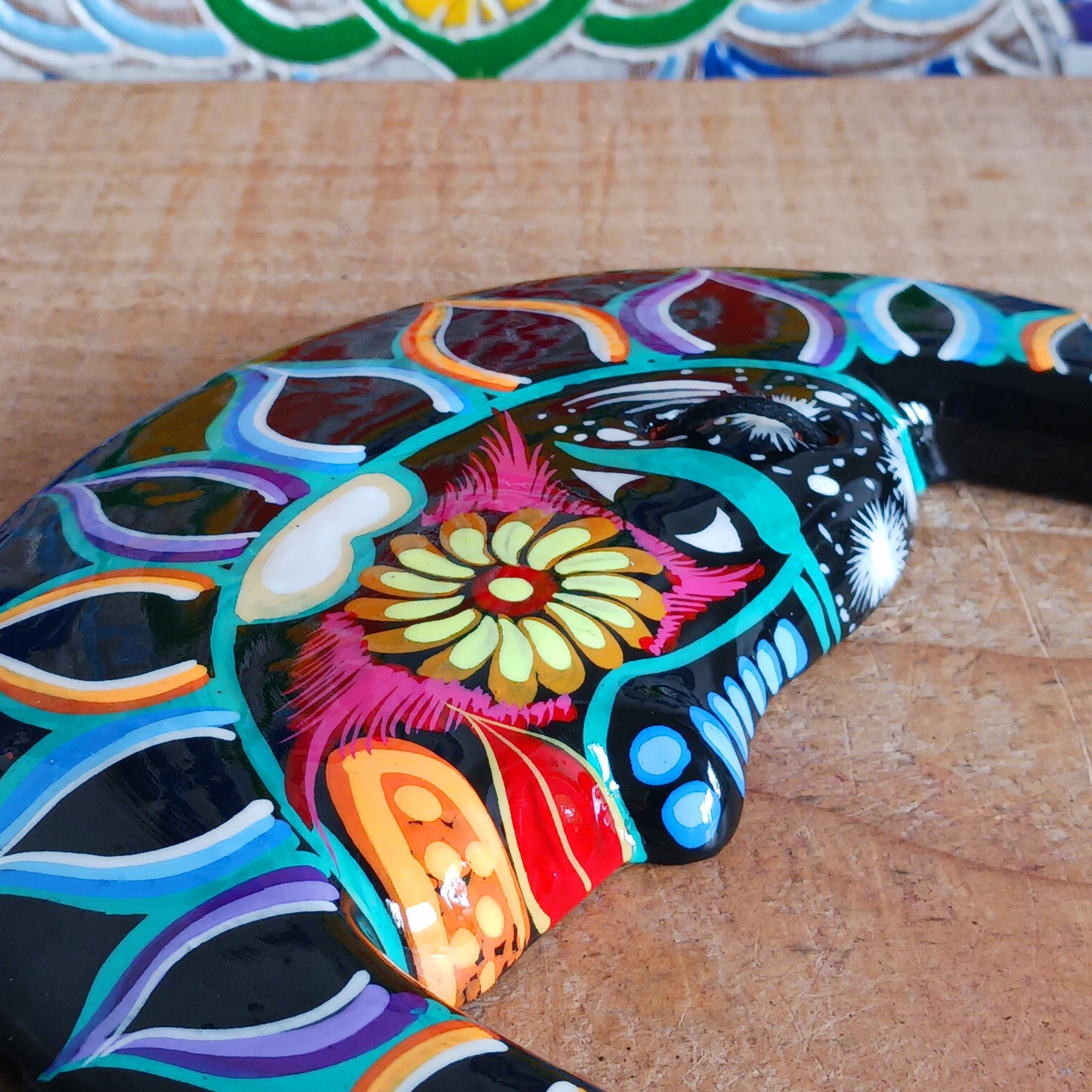 This vibrant wall plaque will have you over the moon! Expertly hand-painted in the bold, colorful style traditional to Xalitla in Guerrero, Mexico, this eye-catching piece celebrates the beauty of authentic Mexican folk art. A striking glaze enhances its vivid design, making it a stunning focal point in any room. The plaque includes two small holes for adding a hanging loop, allowing for easy wall display. Perfect for adding a splash of cultural charm to your home décor or gifting to lovers of artisan craft