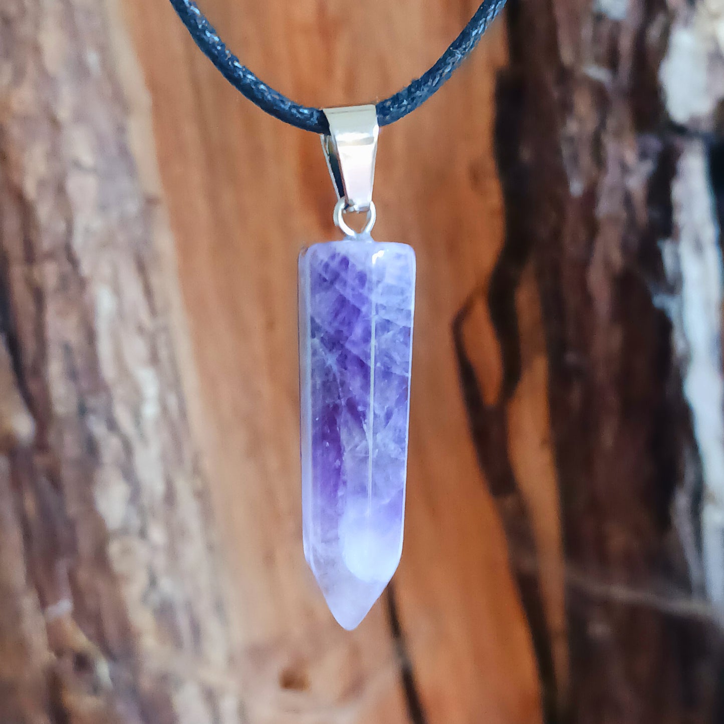 Elevate your style and energy with this stunning Amethyst Crystal Pendant Necklace. Featuring a natural amethyst crystal on a sleek black cord, this piece is both a beautiful accessory and a powerful spiritual tool. Amethyst, known as the stone of spirituality and peace, ranges in shades from soft lavender to deep violet.