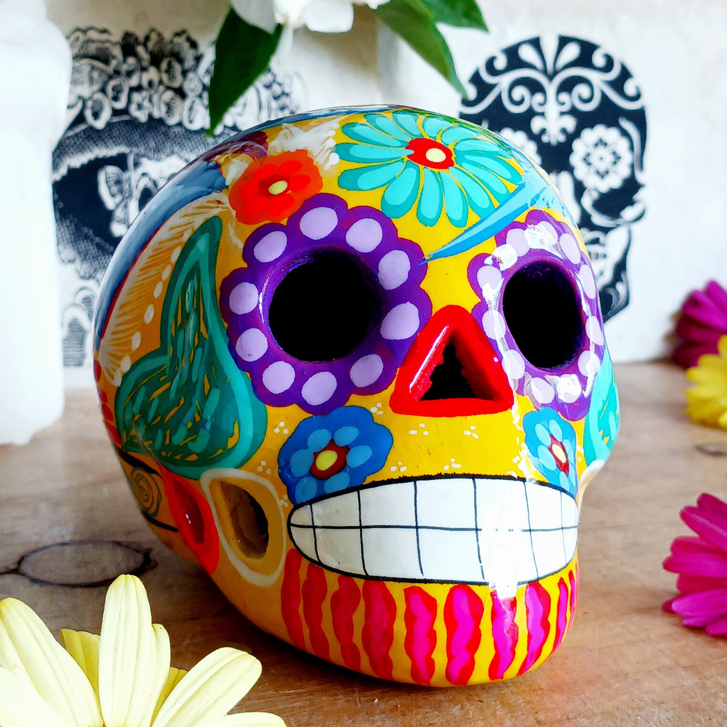 These fun ceramic sugar skull ornaments have been beautifully painted in bright colours and finished with a high shine glaze. They are a popular item during Día de Los Muertos or Day of the Dead festivities, held in Mexico every November to celebrate welcoming the souls of their deceased relatives back for a time of food, drink and celebration.