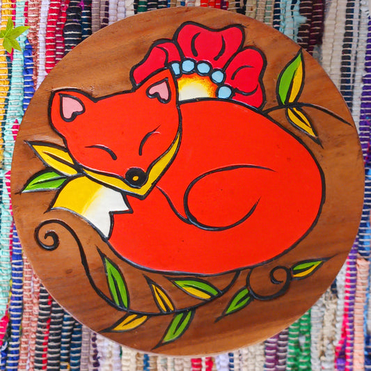 This lovely little handmade, carved and painted stool is Fairtrade from Thailand. The top of this stool has been carefully hand carved and then painted to show a peacefully curled, sleeping fox surrounded by a flower and leaves. These cheeky little items are very versatile making great stools for little bums or as tiny tables to add accent to your home.