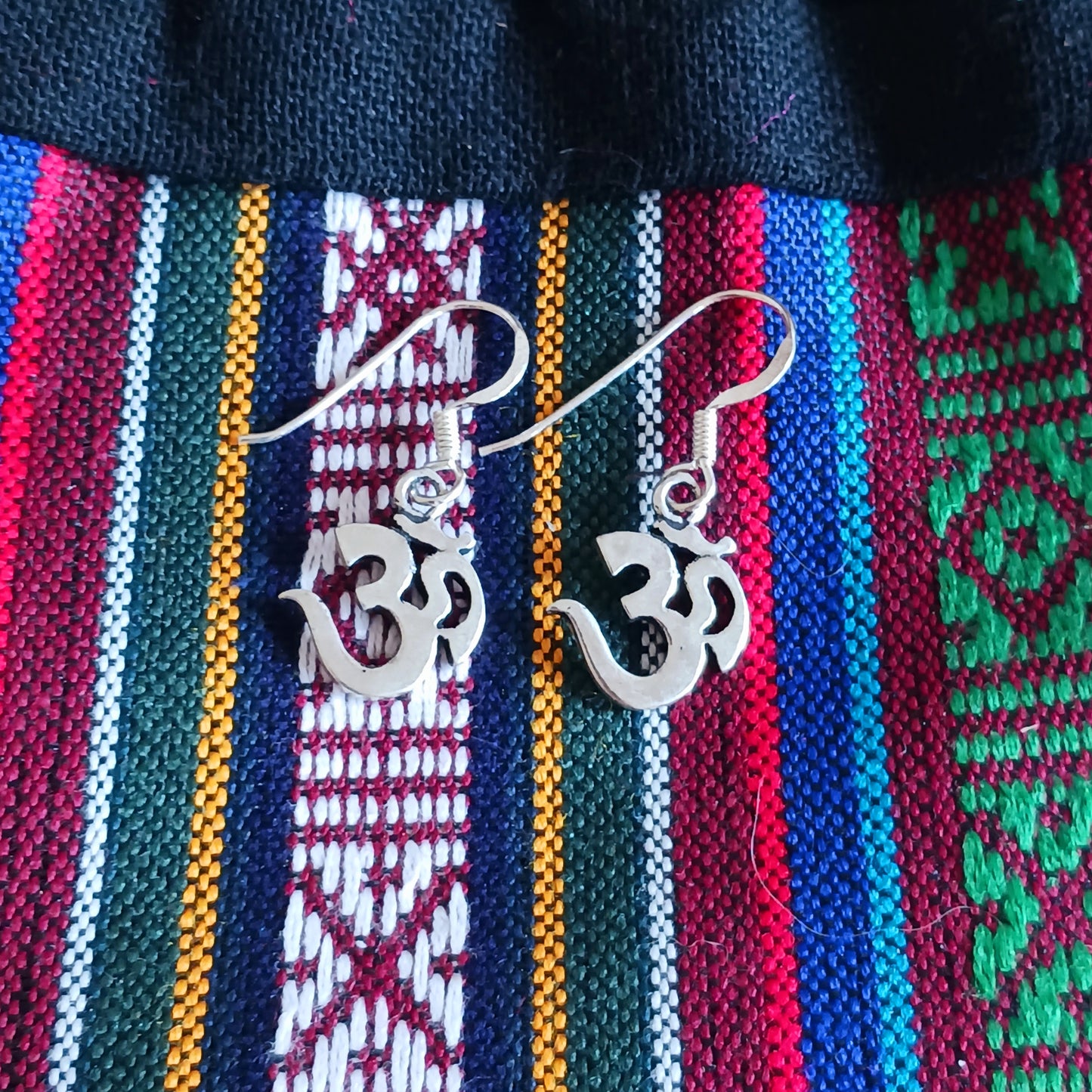 Experience spiritual harmony and elevate your style with these Sterling Silver Om dangle earrings.