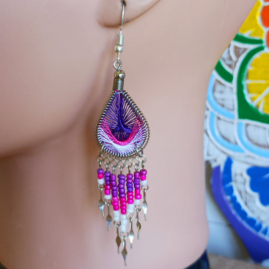 These beautiful and eye-catching earrings are handmade in Peru and feature an array of gorgeous colours. A woven teardrop, similar in style to a peacock feather, is finished with co-ordinating beads and silver embellishments. Ideal for a night out or for dressing up your boho look!