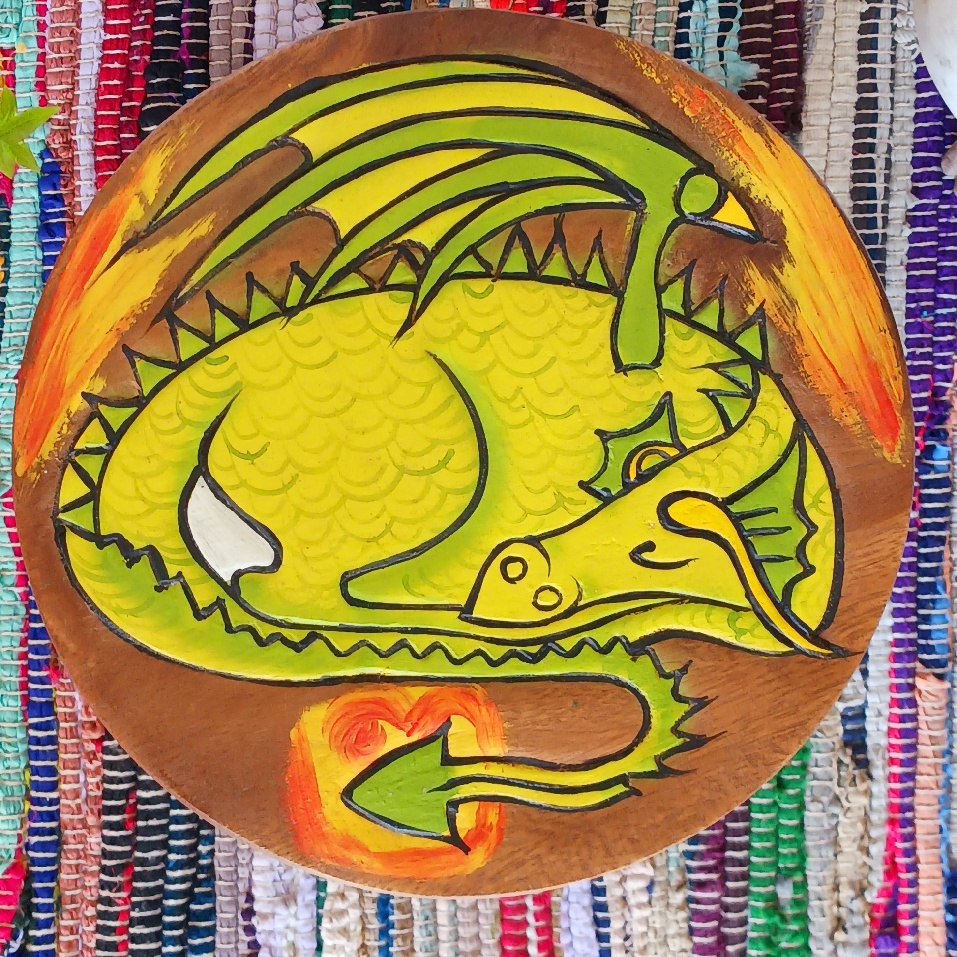 This lovely little handmade, carved and painted stool is Fairtrade from Thailand. The top of this stool has been carefully hand carved and then painted to show a peacefully curled, sleeping dragon surrounded by flames. These cheeky little items are very versatile making great stools for little bums or as tiny tables to add accent to your home. They can also be very useful as a step for those hard to reach high up shelves or even just to put your feet up on, and due to their small form are easy to store.