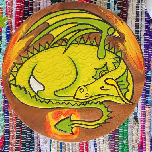 This lovely little handmade, carved and painted stool is Fairtrade from Thailand. The top of this stool has been carefully hand carved and then painted to show a peacefully curled, sleeping dragon surrounded by flames. These cheeky little items are very versatile making great stools for little bums or as tiny tables to add accent to your home. They can also be very useful as a step for those hard to reach high up shelves or even just to put your feet up on, and due to their small form are easy to store.