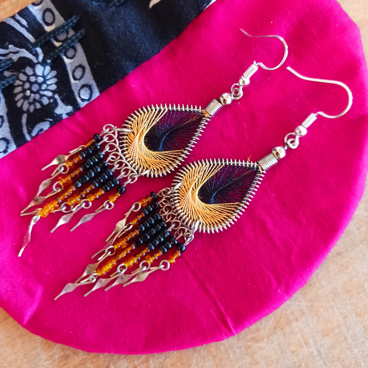 These beautiful and eye-catching earrings are handmade in Peru and feature an array of gorgeous colours. A woven teardrop, similar in style to a peacock feather, is finished with co-ordinating beads and silver embellishments. Ideal for a night out or for dressing up your boho look!