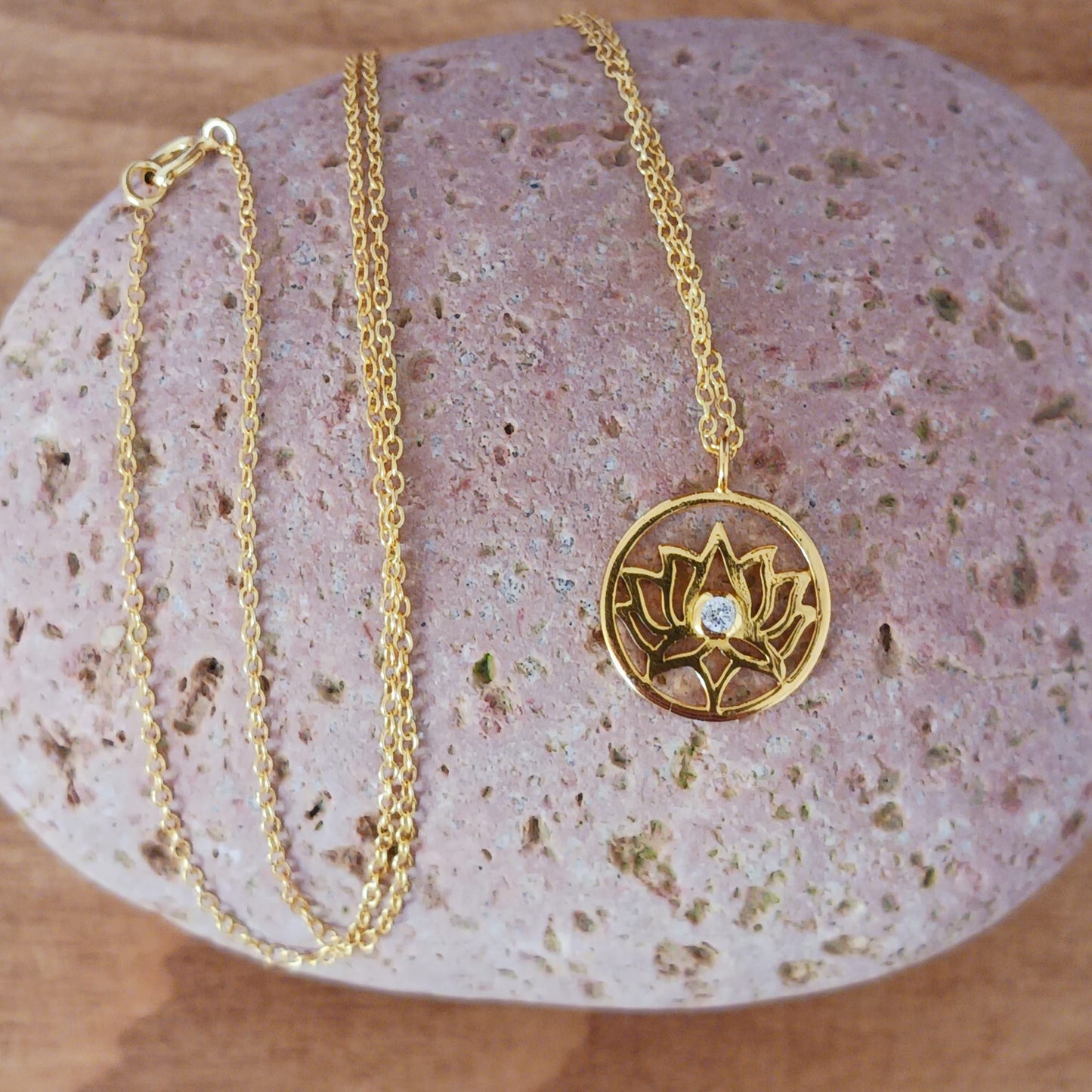 This pretty Lotus Flower pendant is gold plated on 925 silver and has a tiny cz crystal at the centre. It comes on a fine gold plated on 925 silver chain. The lotus flower meaning varies from culture to culture. In general, the lotus commonly serves as a sacred for purity, rebirth, and strength. Because lotuses rise from the mud without stains, they are often viewed as a symbol of purity.