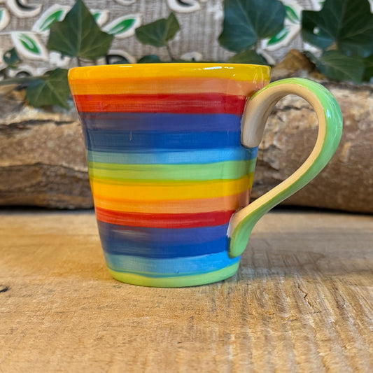 Rainbow Mug , The rainbow stripe is hand painted before it is fired and finishes it beautifully. Narrower in diameter at the bottom and widening towards the rim, these Thai ceramics are traditionally made, hand painted with a pale green interior and finished to a shine glaze highlighting the vibrant multi colours perfectly. A welcoming, uplifting design for every day use.