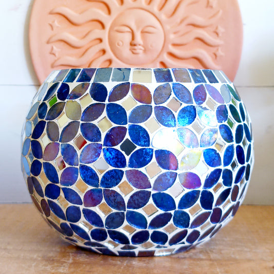 Add a warm, colourful glow to your home with this large and beautiful handmade Meena mosaic glass tealight holder, crafted by a World Fair Trade Organisation (WFTO) approved supplier in India. Featuring a distinctive retro-inspired mosaic pattern, this colourful glass candle holder makes a charming addition to a dining table, shelf, mantelpiece or cosy outdoor setting. These tealight holders are large and can accommodate 3 tealights.