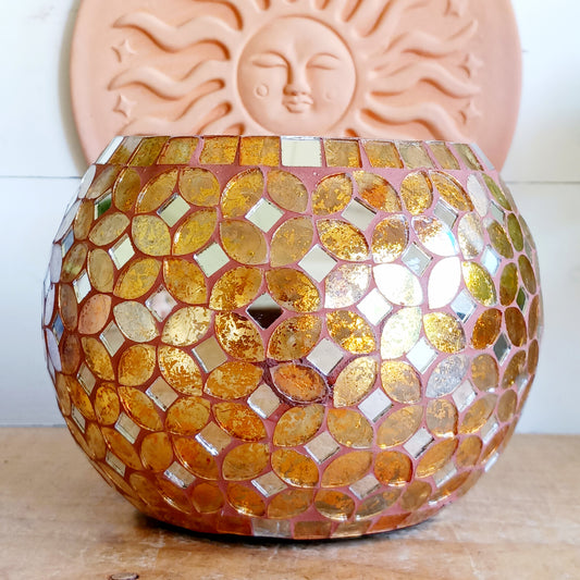 Add a warm, colourful glow to your home with this large and beautiful handmade Meena mosaic glass tealight holder, crafted by a World Fair Trade Organisation (WFTO) approved supplier in India. Featuring a distinctive retro-inspired mosaic pattern, this colourful glass candle holder makes a charming addition to a dining table, shelf, mantelpiece or cosy outdoor setting. These tealight holders are large and can accommodate 3 tealights.