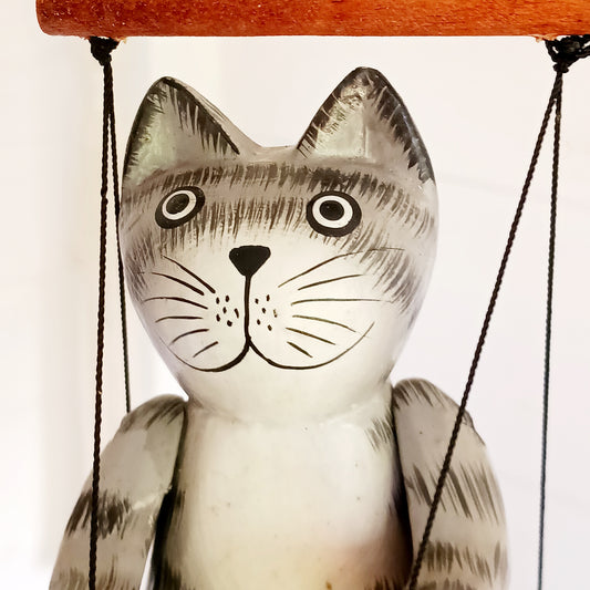 Add a touch of fun and character to your home with this adorable hand-painted wooden bouncing cat! Beautifully hand-painted and carved from albesia wood, this charming feline sits on a little swing suspended from a long spring, allowing it to bounce up and down with a delightful wobble.