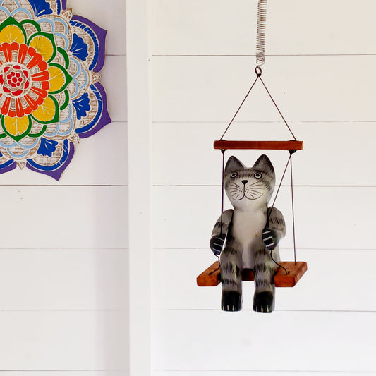 Add a touch of fun and character to your home with this adorable hand-painted wooden bouncing cat! Beautifully hand-painted and carved from albesia wood, this charming feline sits on a little swing suspended from a long spring, allowing it to bounce up and down with a delightful wobble.