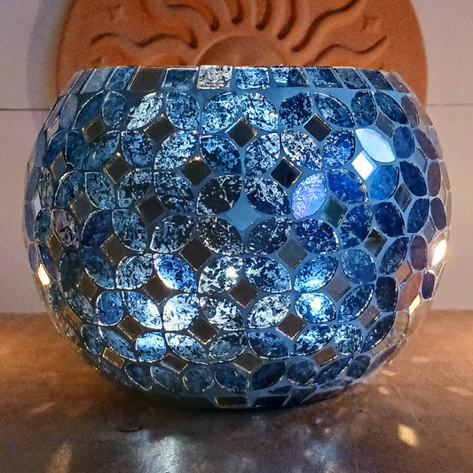 Add a warm, colourful glow to your home with this large and beautiful handmade Meena mosaic glass tealight holder, crafted by a World Fair Trade Organisation (WFTO) approved supplier in India. Featuring a distinctive retro-inspired mosaic pattern, this colourful glass candle holder makes a charming addition to a dining table, shelf, mantelpiece or cosy outdoor setting. These tealight holders are large and can accommodate 3 tealights.