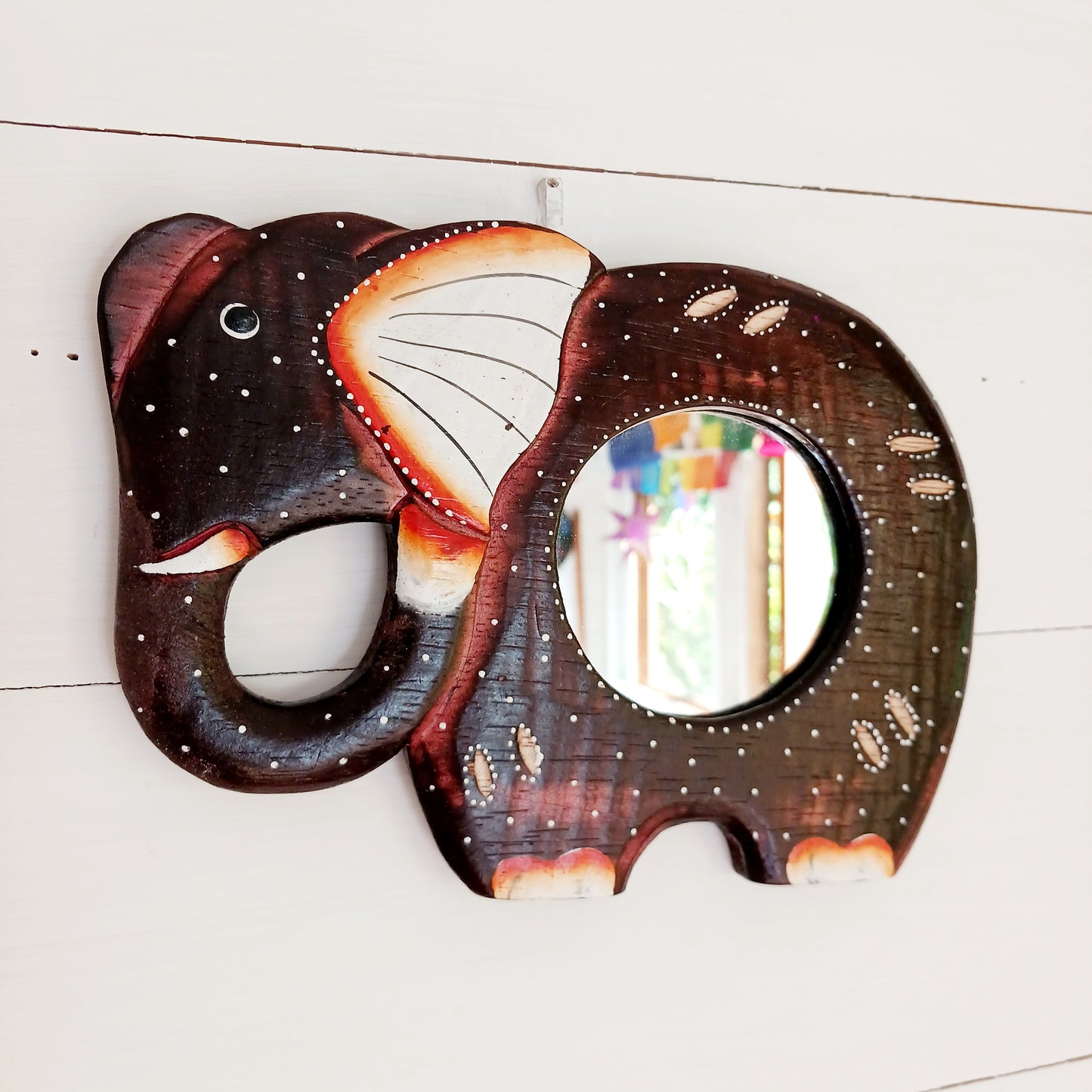 These beautiful little hand carved and hand painted mirrors depict an elephant with gorgeous dot painted detailing.  A cute little gift for elephant lovers!&nbsp;  Each mirror has a metal hoop on the reverse for ease of hanging.