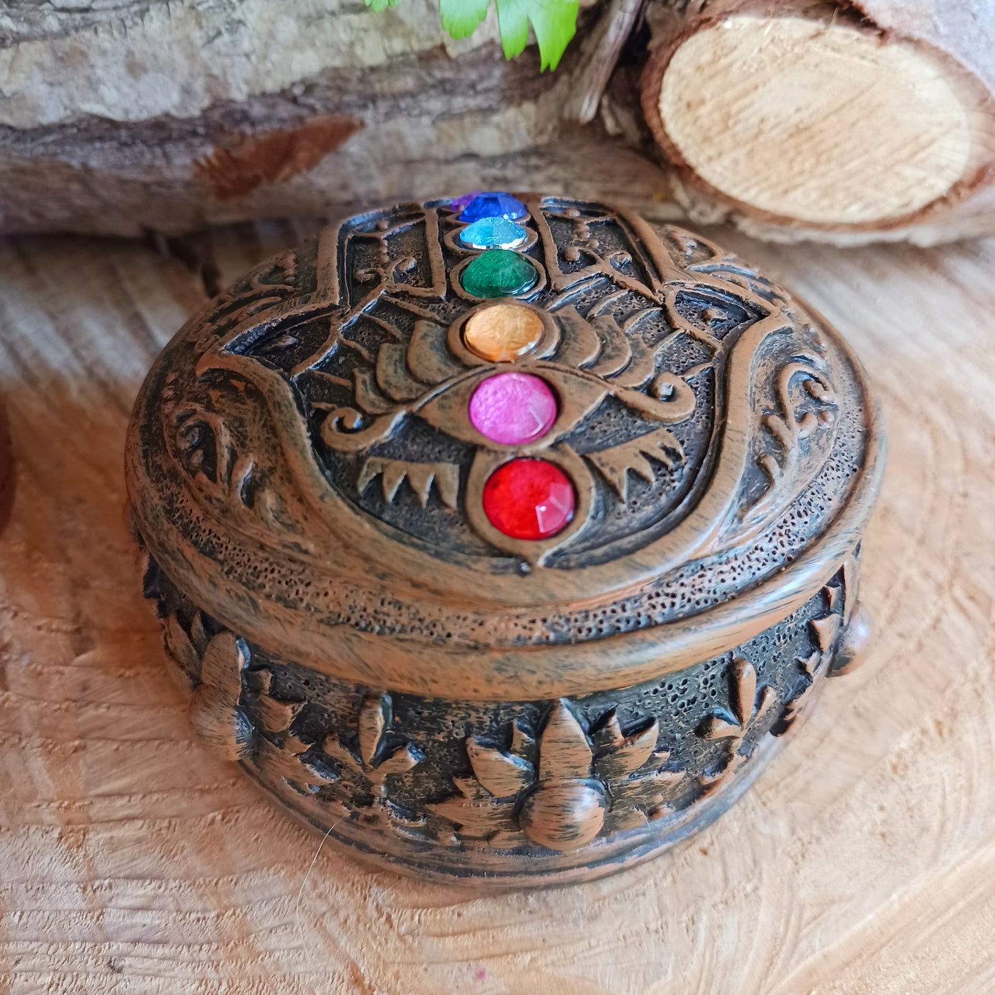 This beautiful Charka Box features Hamsa's Hand which is known for offering protection and happiness to its owners, you can rest assured that your most prized possessions are safe from prying eyes.  With engraved flowers and patterns around the side of the box, and finished with coloured gemstones on the top of the lid. This piece is perfect for anyone who needs a little protection in their life.