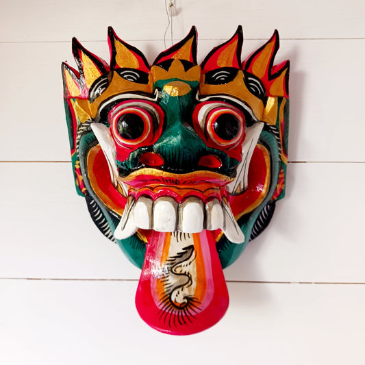 The Rangda mask is a traditional Balinese mask seen in the Barong dance. The mask depicts Rangda who is the queen of witches and represents the personification of all evil. She is depicted with a grotesque visage with protruding fangs, wild goggle eyes and long tongue. In the dance, she leads a terrifying army of witches against the forces of good and their leader, Barong.