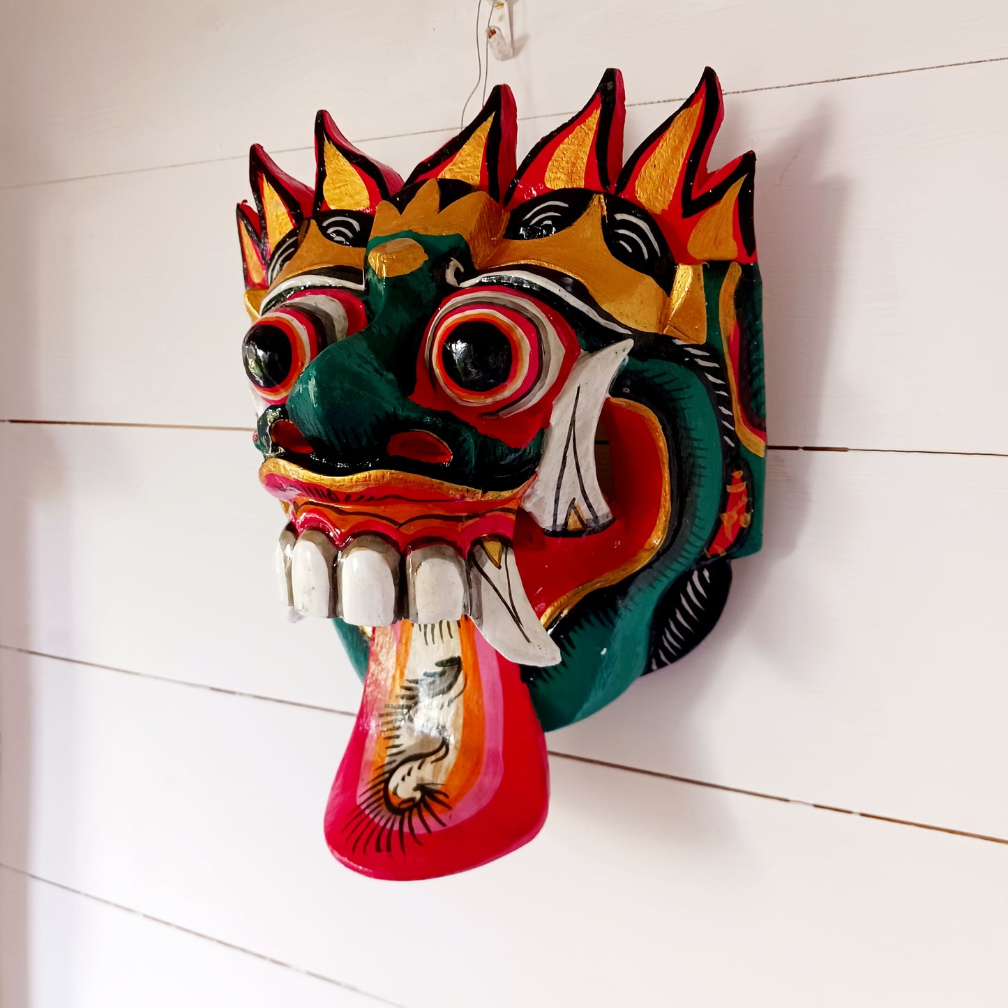 The Rangda mask is a traditional Balinese mask seen in the Barong dance. The mask depicts Rangda who is the queen of witches and represents the personification of all evil. She is depicted with a grotesque visage with protruding fangs, wild goggle eyes and long tongue. In the dance, she leads a terrifying army of witches against the forces of good and their leader, Barong.