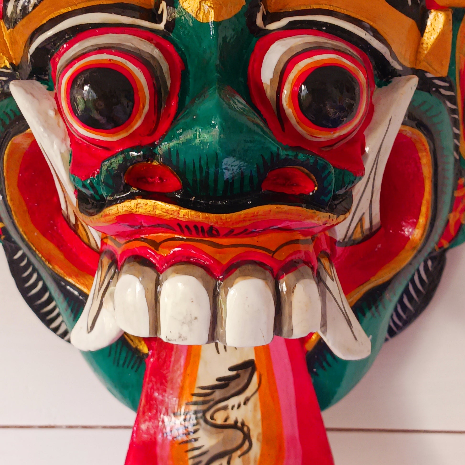 The Rangda mask is a traditional Balinese mask seen in the Barong dance. The mask depicts Rangda who is the queen of witches and represents the personification of all evil. She is depicted with a grotesque visage with protruding fangs, wild goggle eyes and long tongue. In the dance, she leads a terrifying army of witches against the forces of good and their leader, Barong.