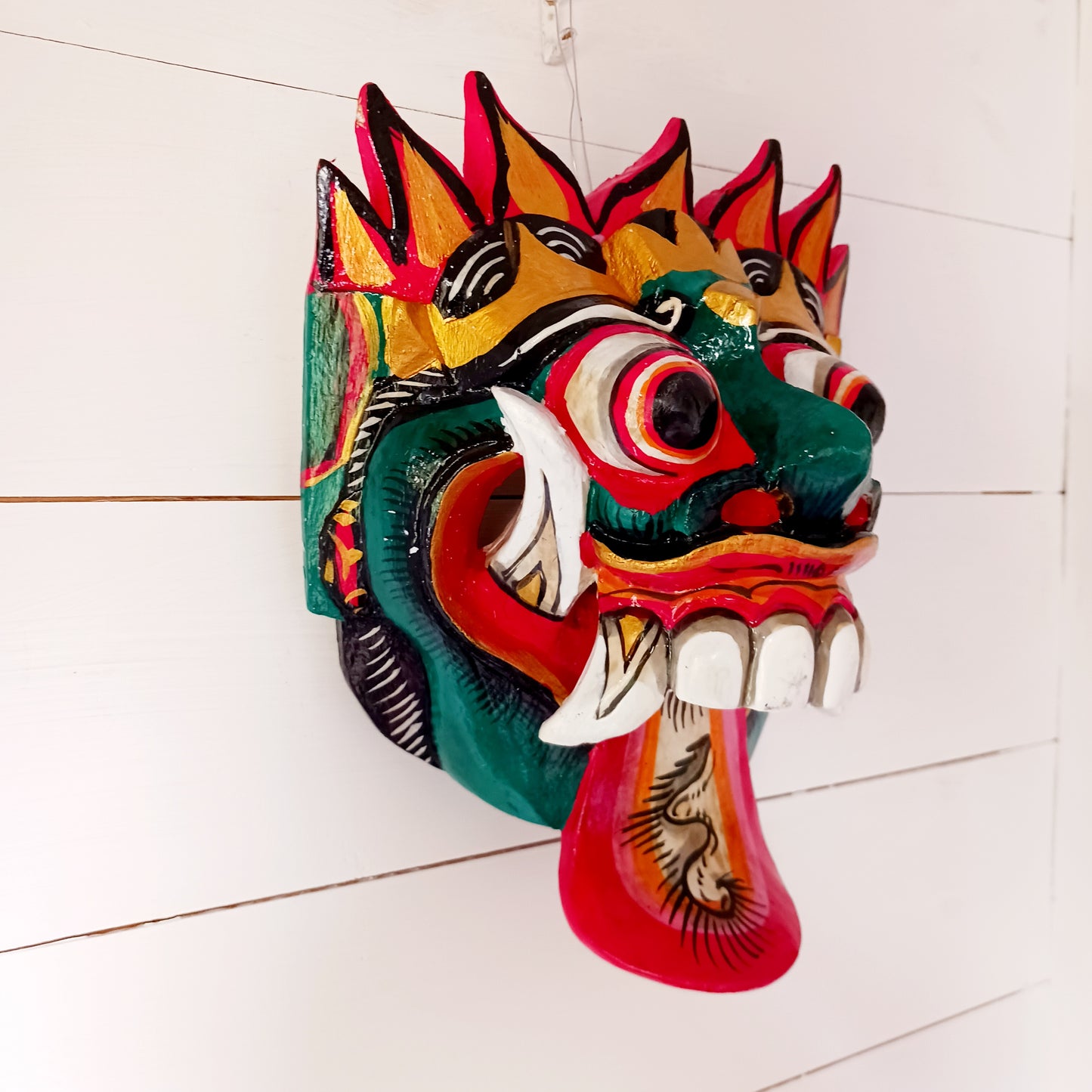 The Rangda mask is a traditional Balinese mask seen in the Barong dance. The mask depicts Rangda who is the queen of witches and represents the personification of all evil. She is depicted with a grotesque visage with protruding fangs, wild goggle eyes and long tongue. In the dance, she leads a terrifying army of witches against the forces of good and their leader, Barong.