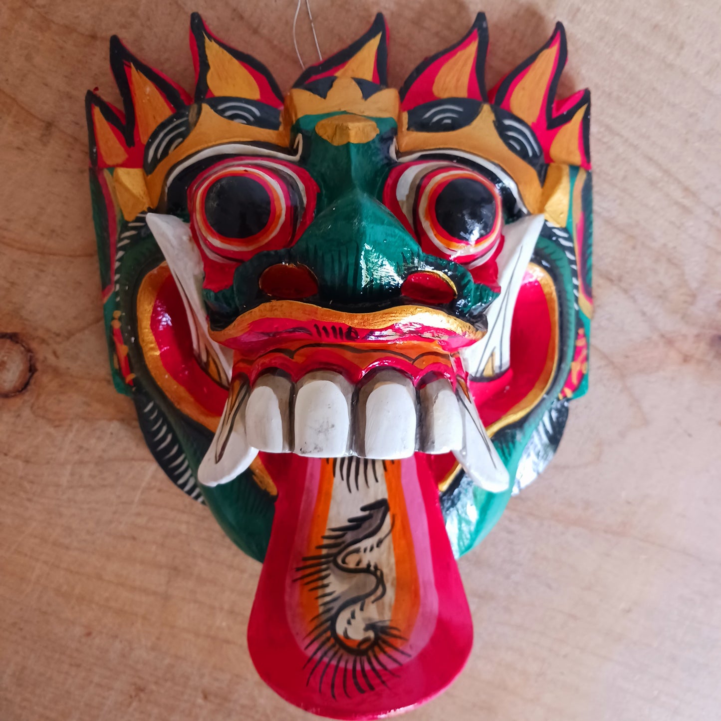 The Rangda mask is a traditional Balinese mask seen in the Barong dance. The mask depicts Rangda who is the queen of witches and represents the personification of all evil. She is depicted with a grotesque visage with protruding fangs, wild goggle eyes and long tongue. In the dance, she leads a terrifying army of witches against the forces of good and their leader, Barong.