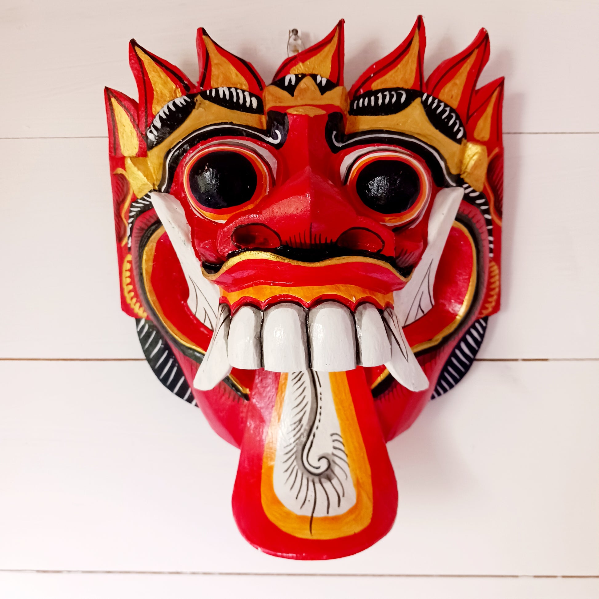 The Rangda mask is a traditional Balinese mask seen in the Barong dance. The mask depicts Rangda who is the queen of witches and represents the personification of all evil. She is depicted with a grotesque visage with protruding fangs, wild goggle eyes and long tongue. In the dance, she leads a terrifying army of witches against the forces of good and their leader, Barong.