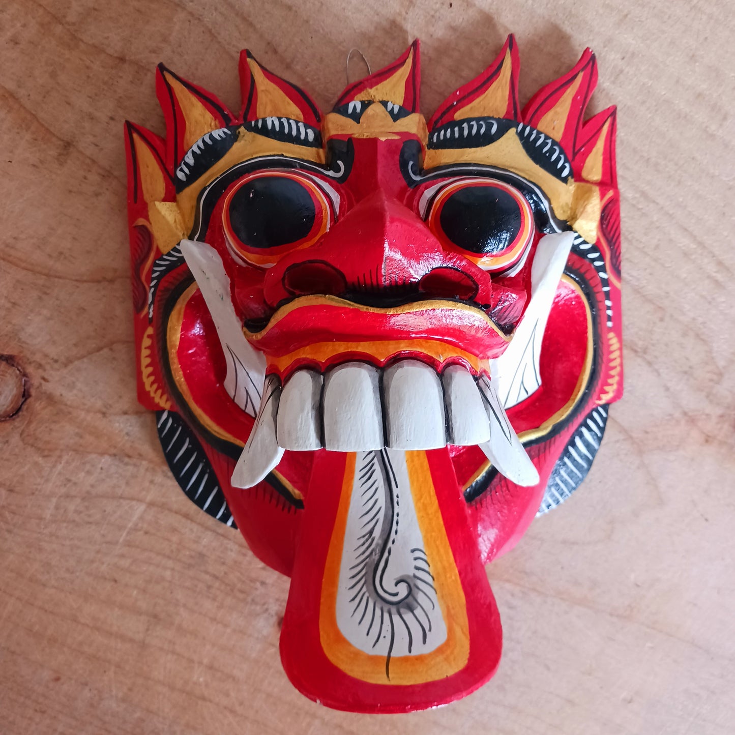 The Rangda mask is a traditional Balinese mask seen in the Barong dance. The mask depicts Rangda who is the queen of witches and represents the personification of all evil. She is depicted with a grotesque visage with protruding fangs, wild goggle eyes and long tongue. In the dance, she leads a terrifying army of witches against the forces of good and their leader, Barong.