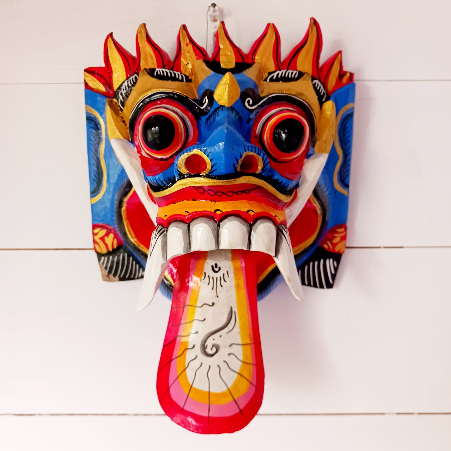 The Rangda mask is a traditional Balinese mask seen in the Barong dance. The mask depicts Rangda who is the queen of witches and represents the personification of all evil. She is depicted with a grotesque visage with protruding fangs, wild goggle eyes and long tongue. In the dance, she leads a terrifying army of witches against the forces of good and their leader, Barong.