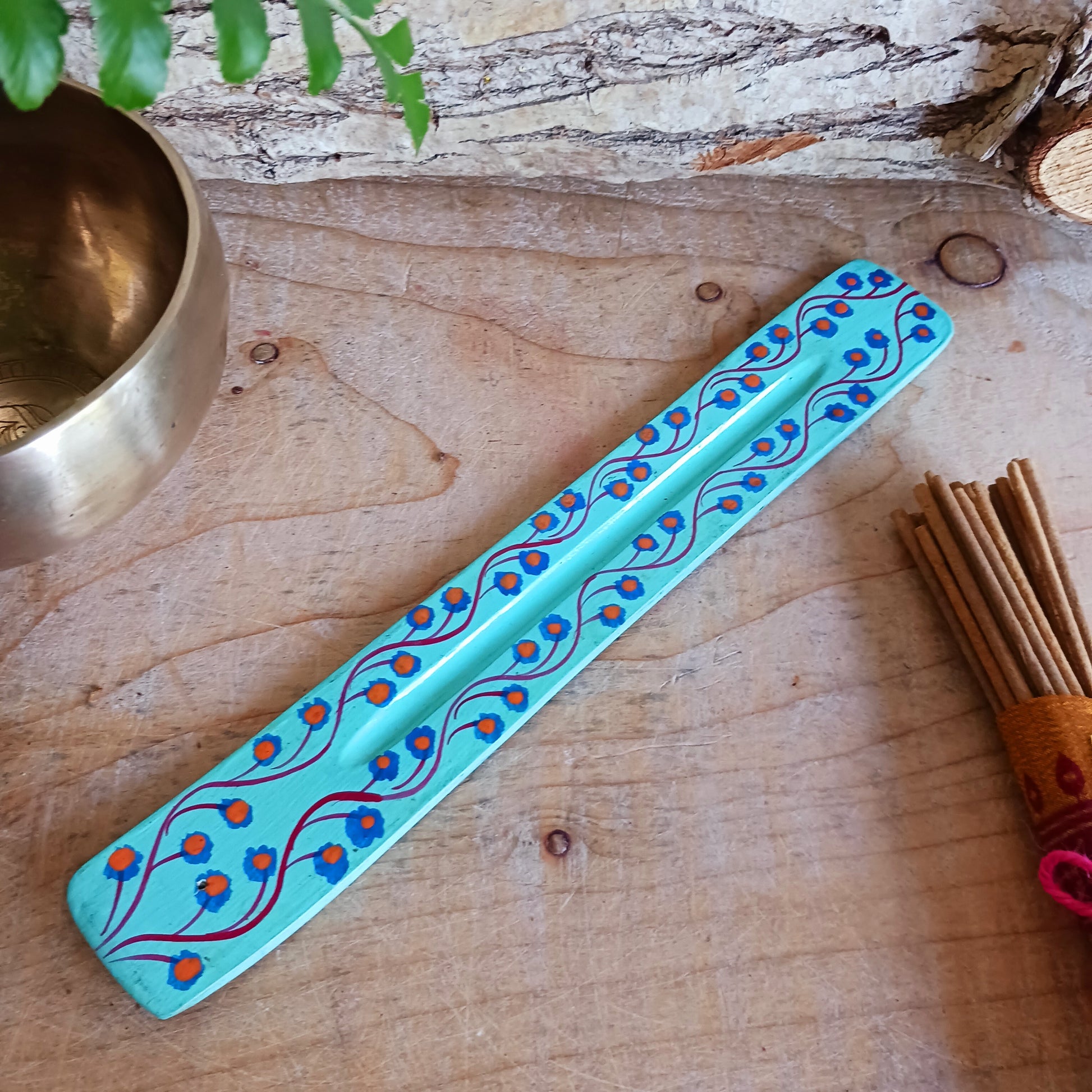 A classic shaped incense holder handmade from sustainable mango wood and hand painted in colourful Indian Truck Art designs. It has a single end incense stick holder at one end. A lovely ornamental piece of Indian décor and a nice gift item.