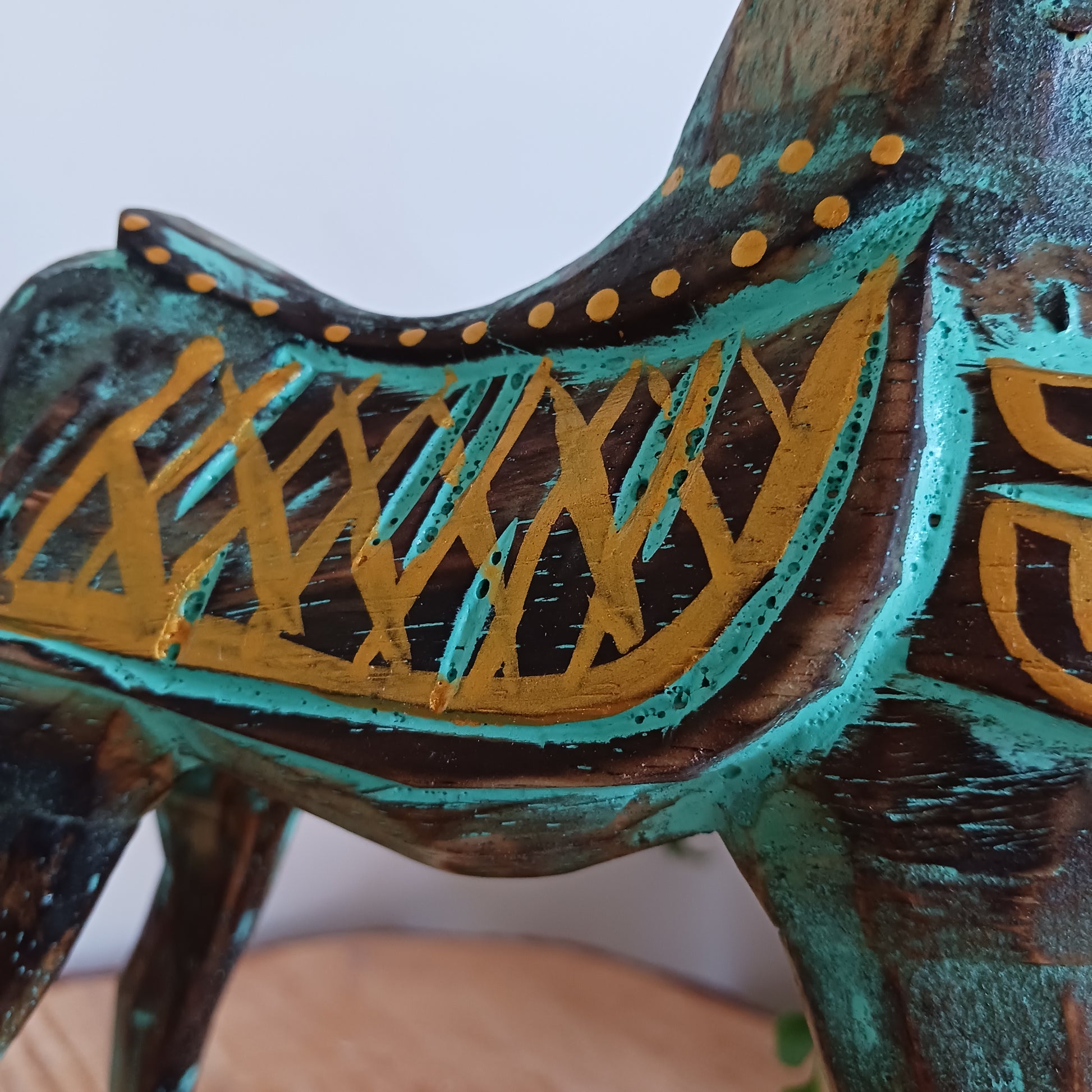 Add a touch of exotic equine elegance to your home with this beautiful hand carved decorative horse figure. Handcrafted from high-quality albasia wood in Indonesia, this striking piece features intricate carvings highlighted in gold and turquoise accents, creating a stunning contrast.