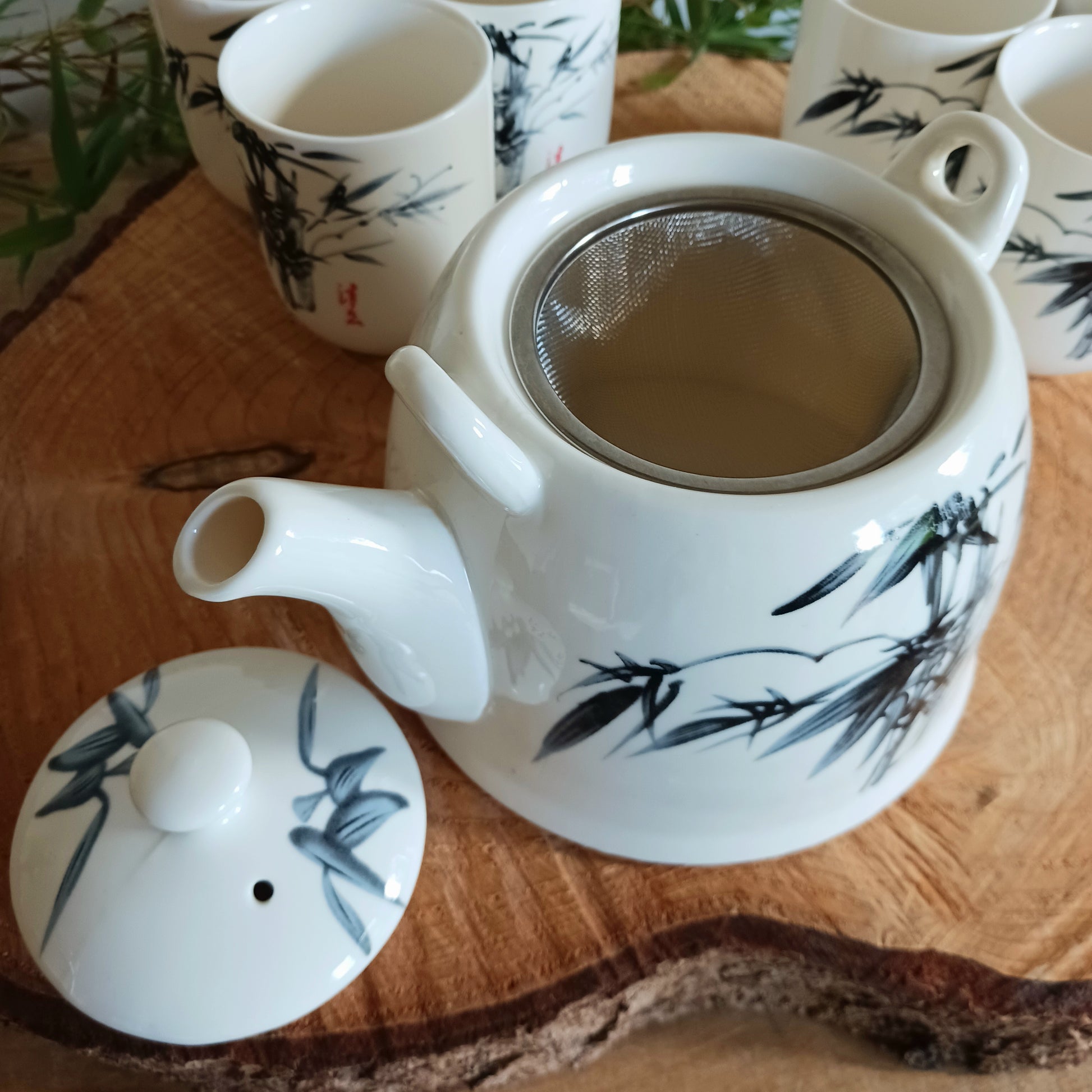 This beautiful Oriental Herbal Teapot Set is made in a ceramic white stone Oriental bamboo design.  Packed in a gift box, a teapot with a metal strainer in the lid, a detachable handle and six matching little cups.