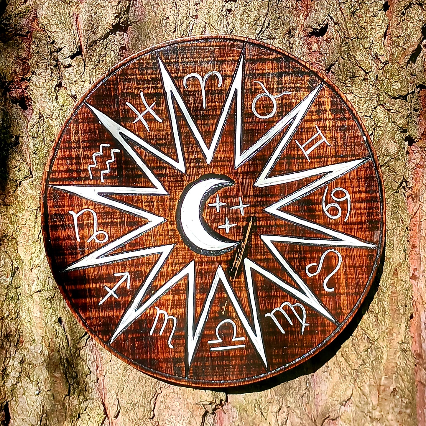 Hand carved and hand painted, this wooden wall plaque features a crescent moon and zodiac symbols design. A unique plaque for your garden.