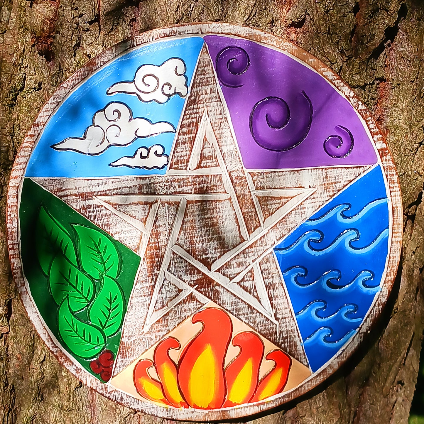 This beautifully finished mango wood wall plaque depicts the five great elements – Earth, Water, Fire, Air and Ether. These hand painted, brightly coloured elements are tied together with a central pentagram, with a natural whitewash finish.