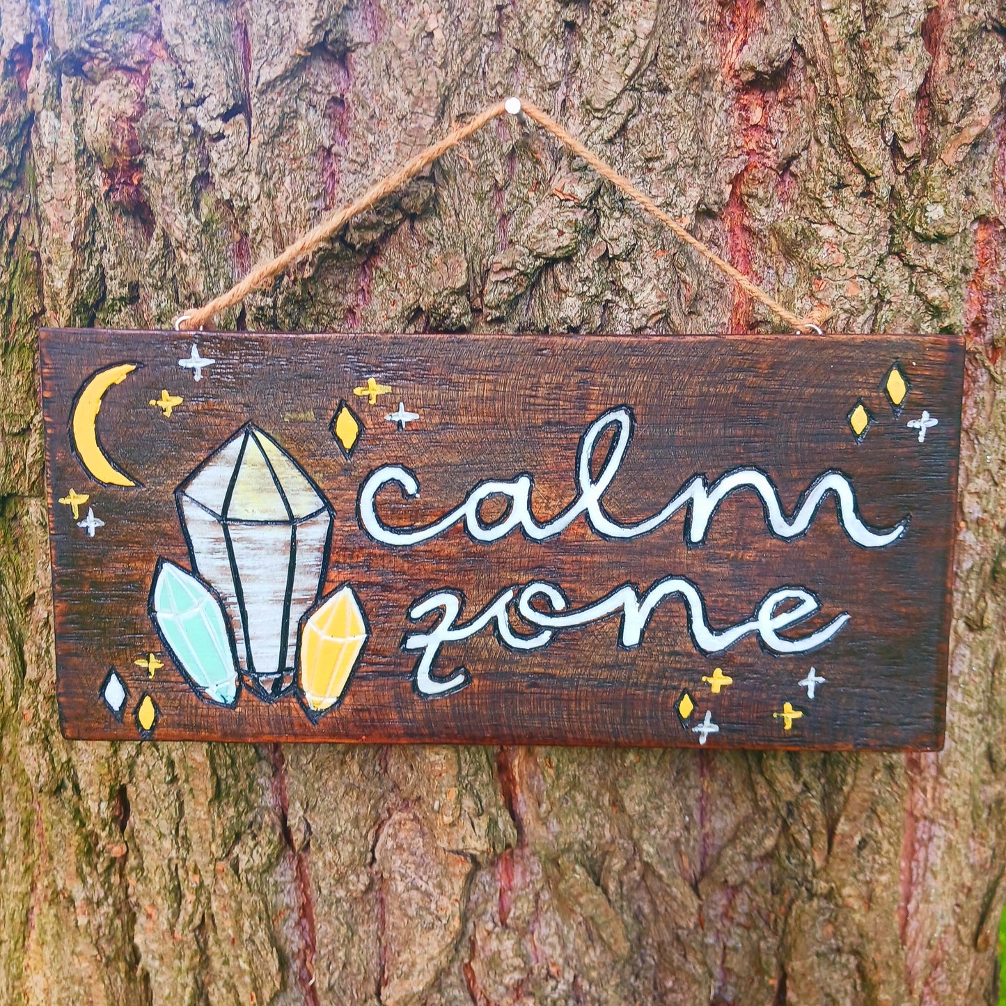 Perfect for your meditation area, this hand painted sign features crystals and stars in a soft palette and white wash effect. The plaque has a twine string, perfect for hanging from any wall or door.