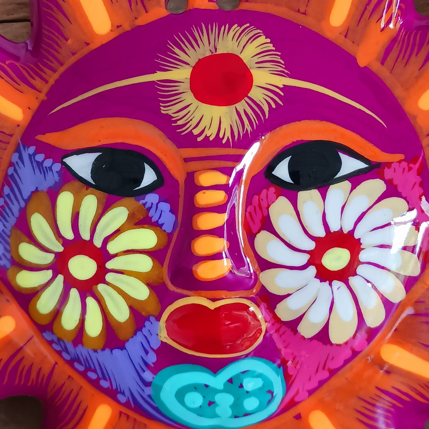 This sunny and vibrant wall plaque will get you smiling! It has been beautifully hand painted in a bright style traditional to Xalitla, a region of Guerrero, Mexico. A striking glaze adds to the bold design. It has two holes which can be used to add a hanging loop for an easy display.