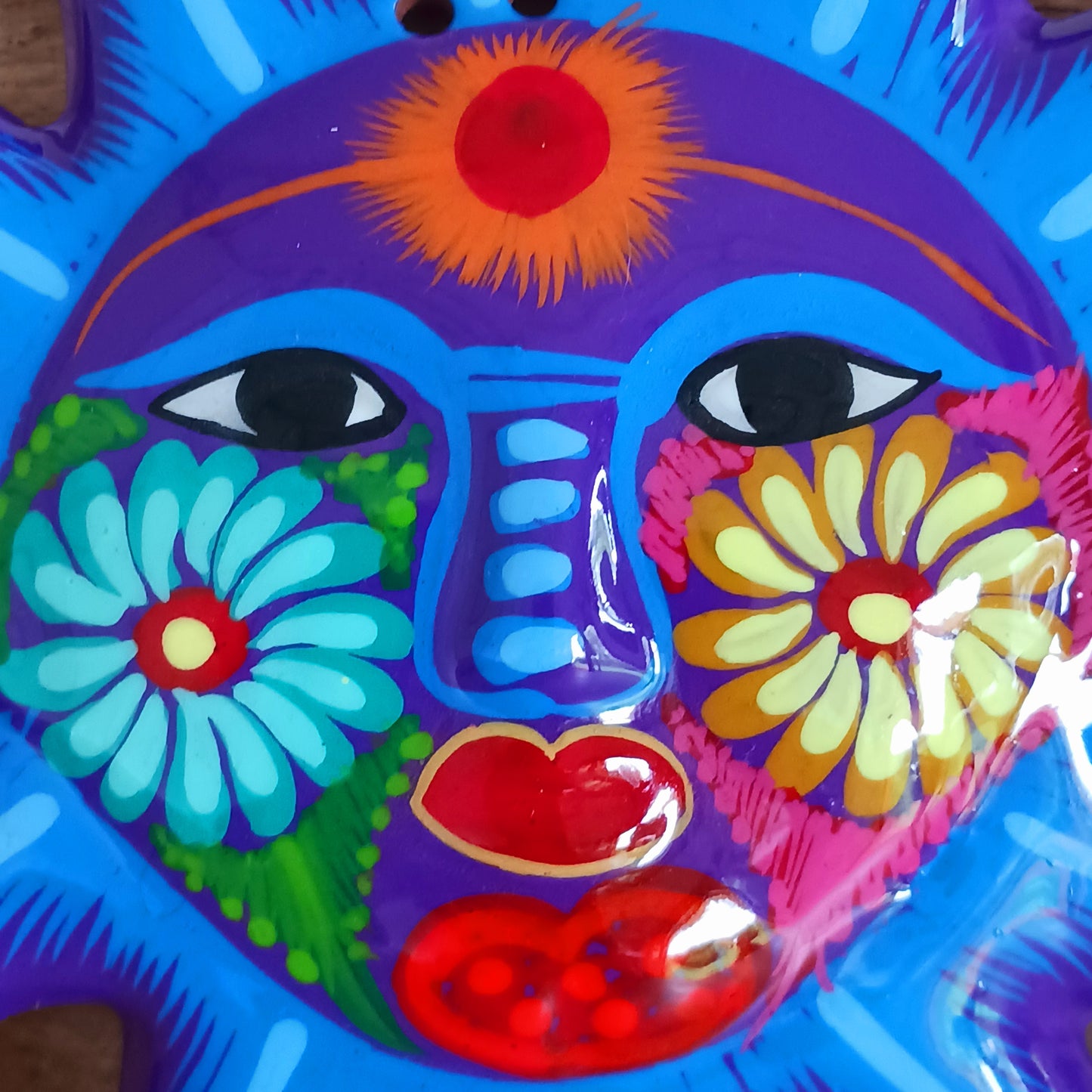 This sunny and vibrant wall plaque will get you smiling! It has been beautifully hand painted in a bright style traditional to Xalitla, a region of Guerrero, Mexico. A striking glaze adds to the bold design. It has two holes which can be used to add a hanging loop for an easy display.