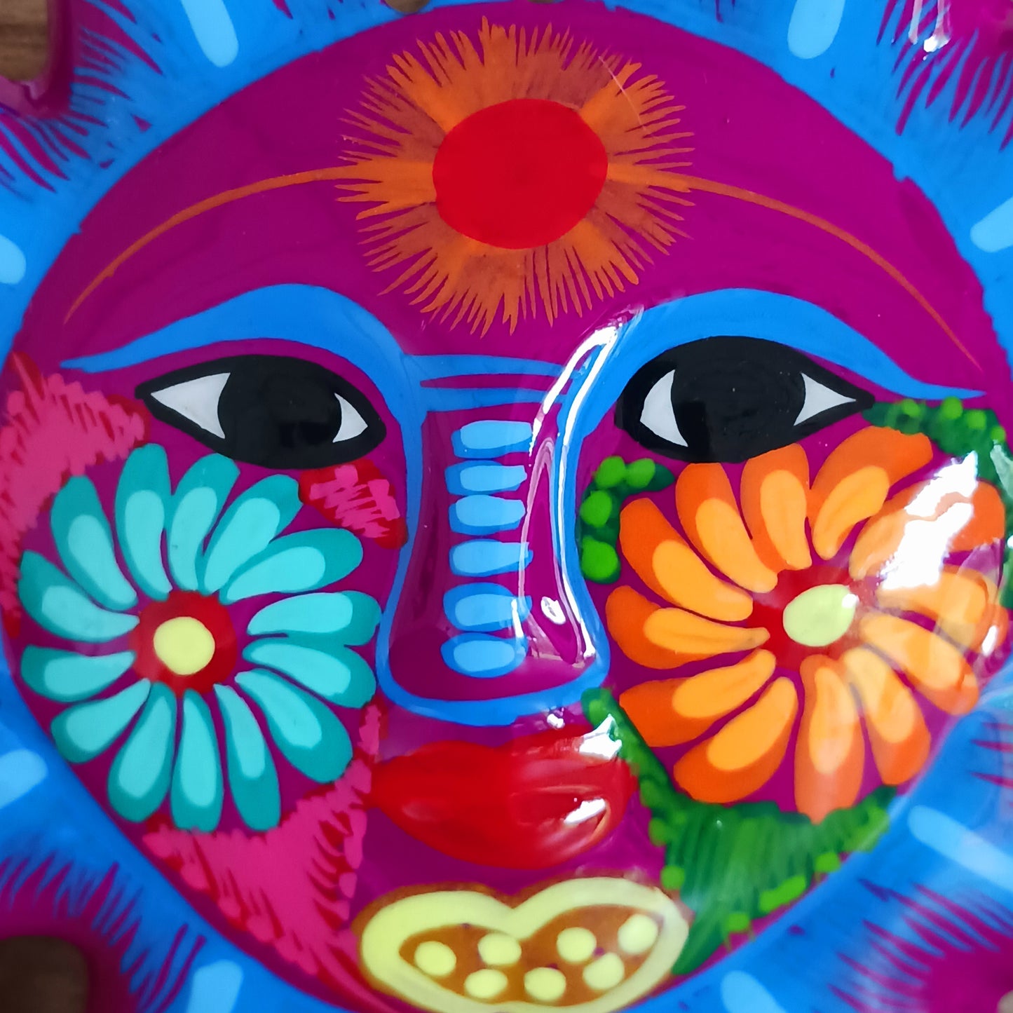 This sunny and vibrant wall plaque will get you smiling! It has been beautifully hand painted in a bright style traditional to Xalitla, a region of Guerrero, Mexico. A striking glaze adds to the bold design. It has two holes which can be used to add a hanging loop for an easy display.