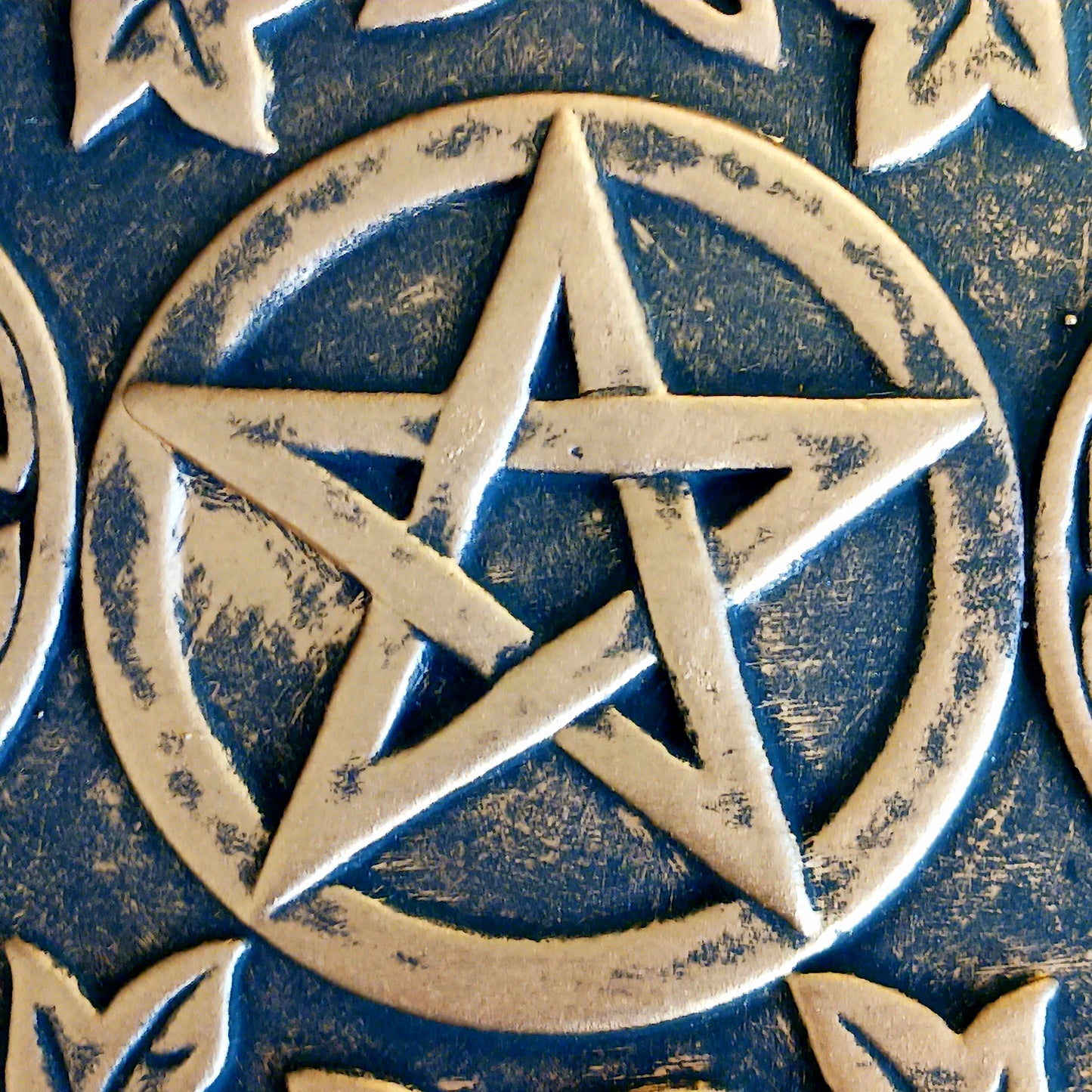 The plaque depicts a triple moon design also referred to as the triple goddess. The symbol represents the Maiden, Mother and Crone as the waxing, full and waning moon and is often related to feminine energy and psychic abilities.