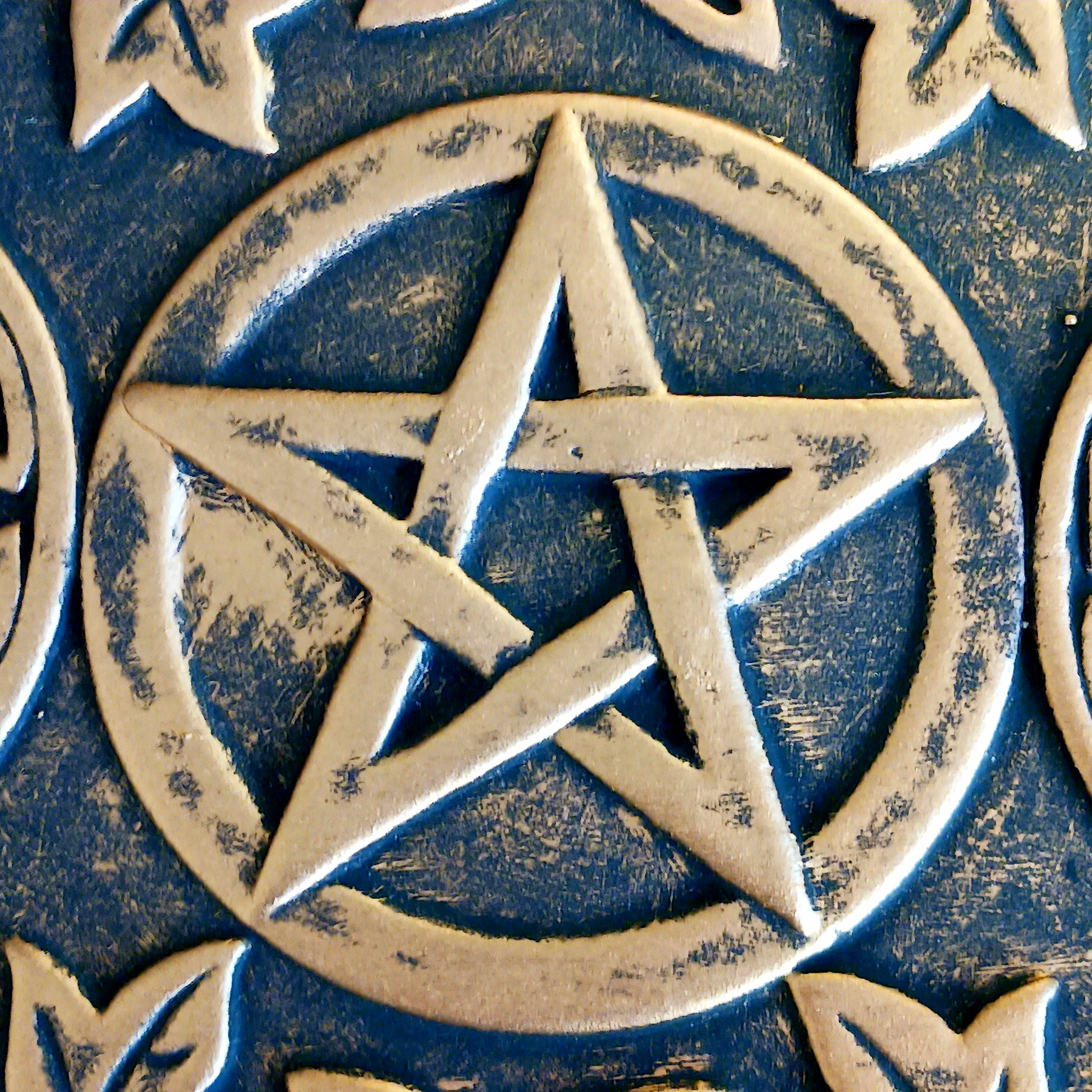 The plaque depicts a triple moon design also referred to as the triple goddess. The symbol represents the Maiden, Mother and Crone as the waxing, full and waning moon and is often related to feminine energy and psychic abilities.