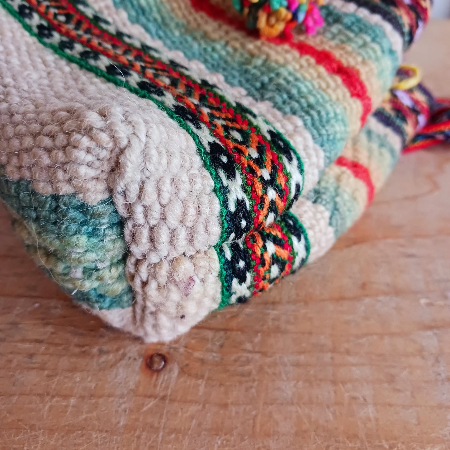 This cute sheepswool drawstring bag has been created using naturally dyed colourful wools to create handy sized day bag, perfect for carrying your purse and keys, and as a festival bag. Two pom poms have been added as a finishing touch. The bag itself is fully lined and the straps have been made using traditional manta fabrics. Inside is cotton lined.