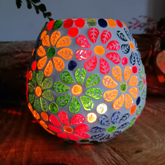 These beautiful tealight holders are a mosaic mixture of pattern in vibrant block colours that create a floral medley design.  Pop in a lit tealight to warm the atmosphere with multi colour vibes on outdoor summer evenings, or indoors to brighten the long dark evenings.