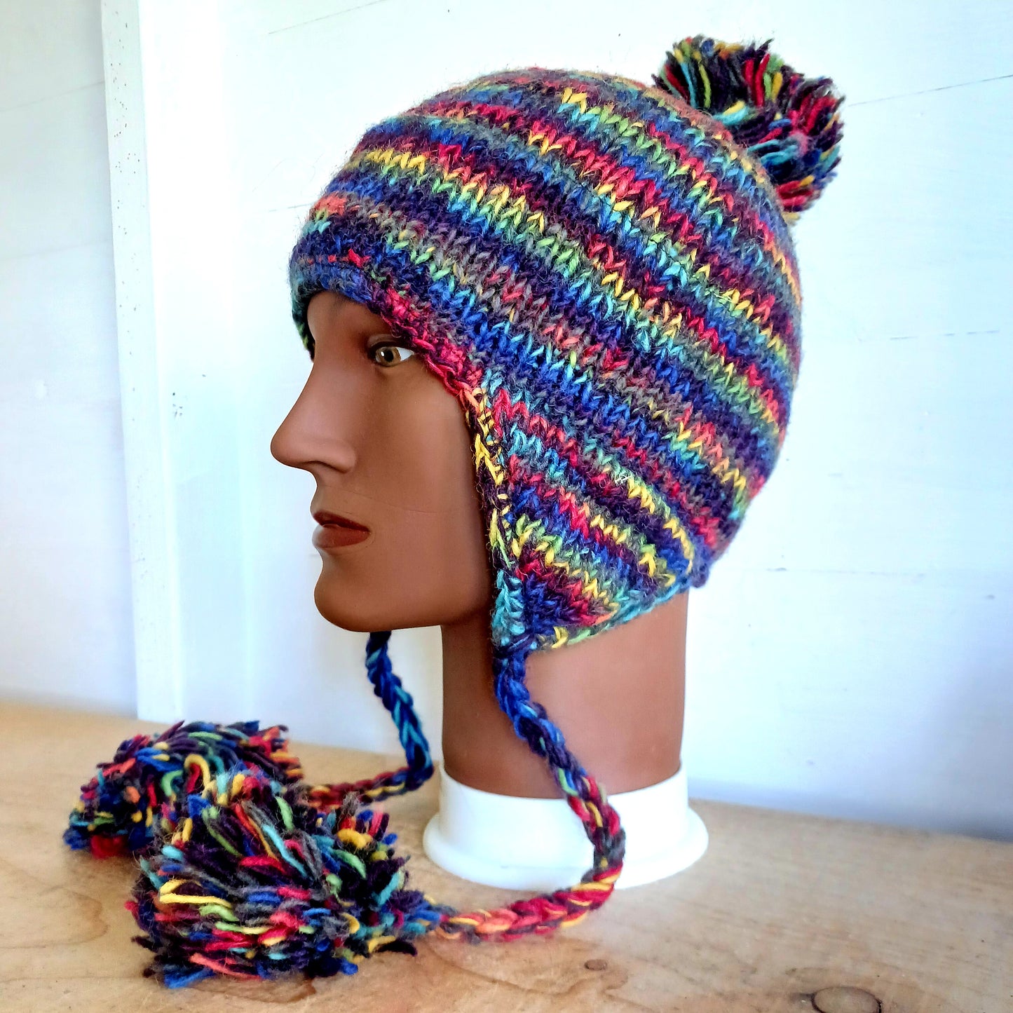 This Hasri space dye earflap hat is a fun and snuggly hat with matching pom poms.  Chunky knit from tie dye wool with a smooth fleece lining so it's lovely and comfortable to wear and keep you extra warm.  Perfect for winter days out!