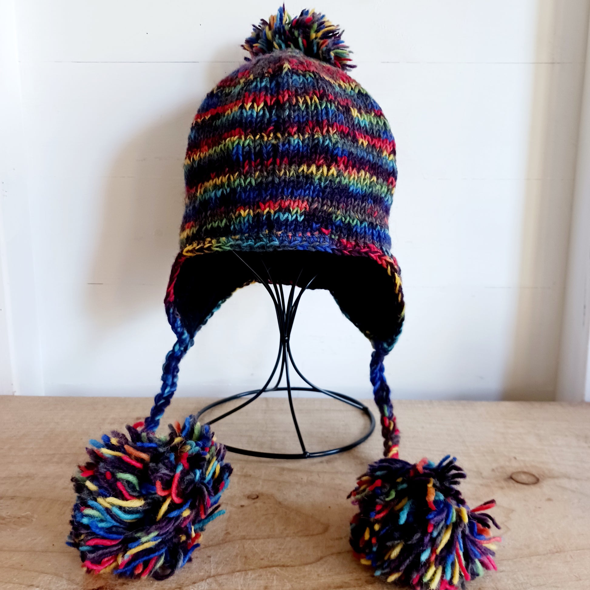 This Hasri space dye earflap hat is a fun and snuggly hat with matching pom poms.  Chunky knit from tie dye wool with a smooth fleece lining so it's lovely and comfortable to wear and keep you extra warm.  Perfect for winter days out!