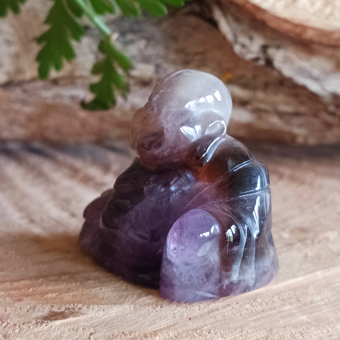 This beautiful miniature handcarved Laughing Buddha has been crafted from genuine Amethyst.  This gemstone Buddha is a jolly and elegant symbol of peace, spiritual growth, and inner clarity.