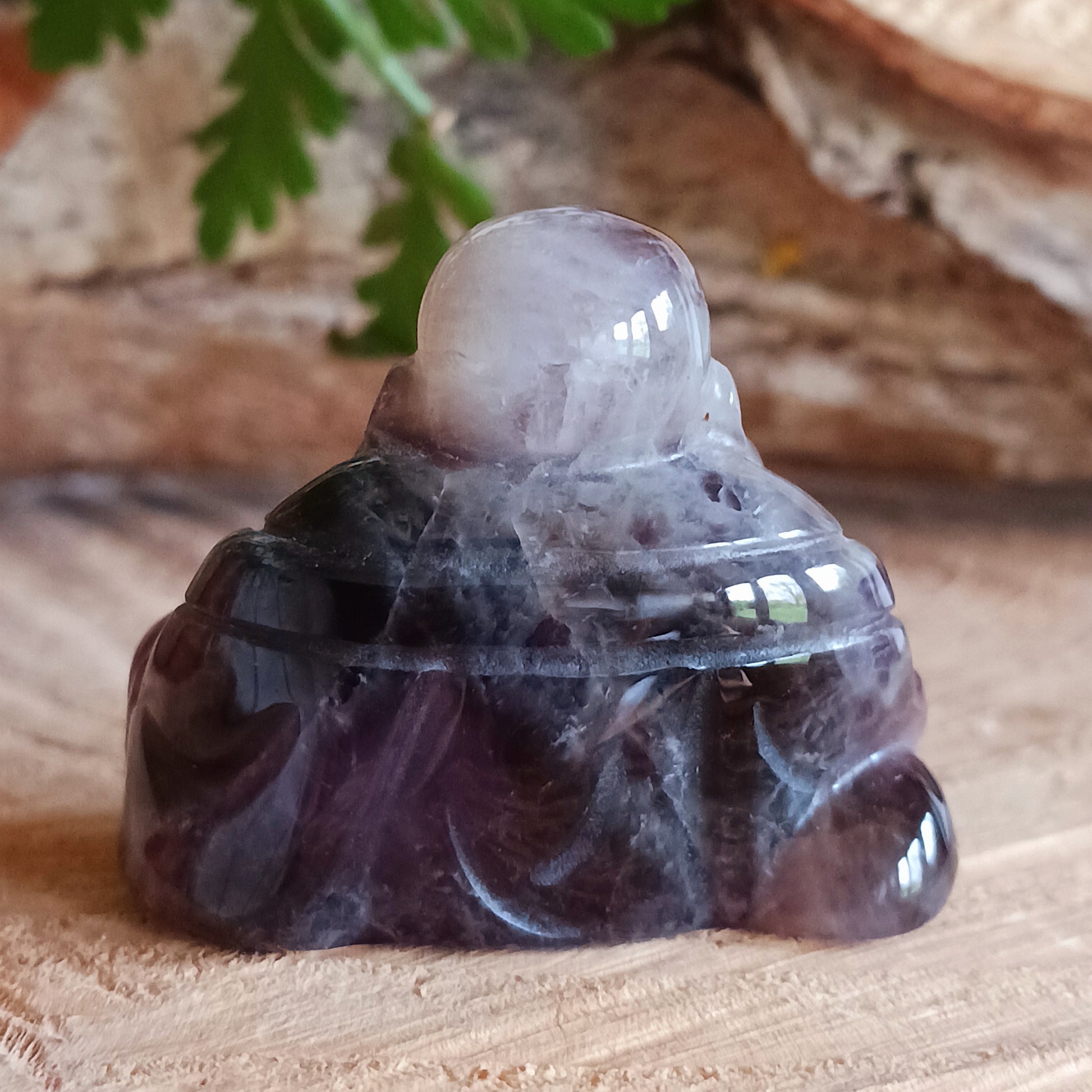 This beautiful miniature handcarved Laughing Buddha has been crafted from genuine Amethyst.  This gemstone Buddha is a jolly and elegant symbol of peace, spiritual growth, and inner clarity.